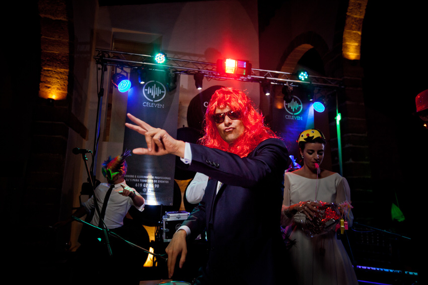novio con una peluca roja divertiendose en su fiesta de boda